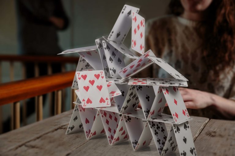 Girl making a card house with Cartamundi Cards
